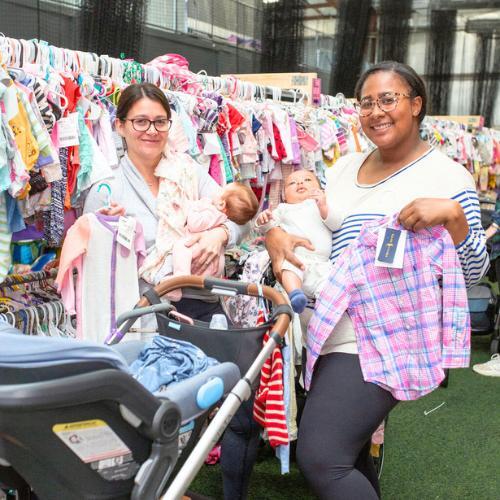 A mother and daughter stand side by side in their masks as they shop their local JBF sale.